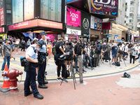 Police monitor an activist talking to livestreamers in Causeway Bay, in Hong Kong, China, on May 30, 2021. (