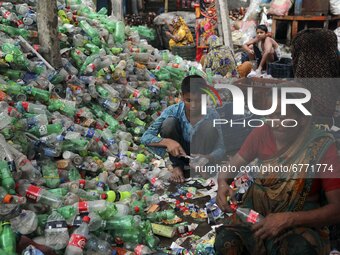 Female laborers sort through polyethylene terephthalate (PET) bottles in a recycling factory in Dhaka Bangladesh on June 02, 2021. Recycling...