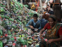 Female laborers sort through polyethylene terephthalate (PET) bottles in a recycling factory in Dhaka Bangladesh on June 02, 2021. Recycling...