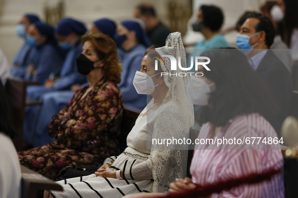 A woman wearing a traditional back comb (peineta) with a face mask during the traditional Mass of the Corpus Christi in the Cathedral on Jun...