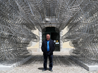 Chinese artist Ai Weiwei poses in front of his sculpture 