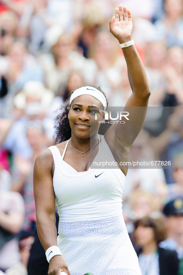 Serena Williams celebrates with a wave to the crowd as she overcomes Viktoria Azarenka in three sets during day eight of the Wimbledon Lawn...