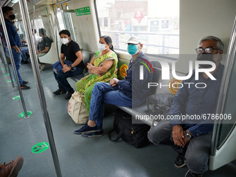 Commuters wearing masks travel inside a Delhi Metro train after resumption of services in a graded manner at 50% capacity, in New Delhi, Ind...