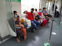 Commuters wearing masks travel inside a Delhi Metro train after resumption of services in a graded manner at 50% capacity, in New Delhi, Ind...