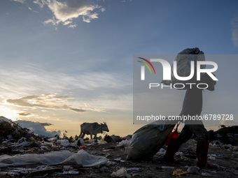 A scavenger carries used goods from his scavenged garbage at the Poi Panda landfill, Kawatuna, Palu City, Central Sulawesi Province, Indones...