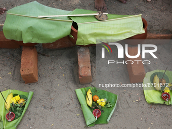 Clay pots covered with a banana leaves containing pongala seen as Hindu women finish the final preparations before cooking pongala along the...