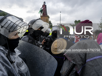 Misak indigenous stand in front of police officers as she protest next to the statue of queen Isabel of Spain on June 09, 2021 in Bogota, Co...