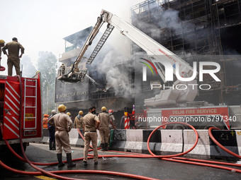 Firefighters try to douse the fire that broke out inside a showroom in Lajpat Nagar's Central Market in New Delhi, India on June 12, 2021. (