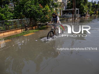 A woman through the flood on a bicycle. Floods that hit Nerada Estate housing, Cipayung, Ciputat, South Tangerang (Tangsel) since Friday (11...