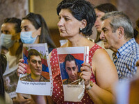 A woman holds photos of her relatives, killed soldiers in the last Nagorno Karabakh conflict with Azerbaijan, during a holy mass in Yerevan,...