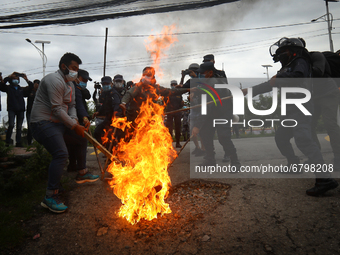 Police personnel attempt to douse an effigy of Nepal’s Prime Minister KP Sharma Oli burnt by the opposition alliance during a Protest agains...