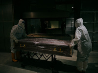Crematorium workers wearing protective suit push the casket of Covid-19 coronavirus patient for cremation process at Bliss Garden crematoriu...
