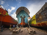 Dockyard workers carry on maintenance works on the hull of a ship on the bank of the Buriganga River in Dhaka, Bangladesh on June 13, 2021....