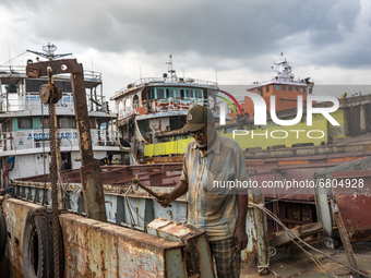 Dockyard workers carry on maintenance works on the bank of the Buriganga River in Dhaka, Bangladesh on June 13, 2021. Twenty-eight dockyards...