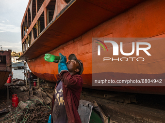 Dockyard worker drinks water on the bank of the Buriganga River in Dhaka, Bangladesh on June 13, 2021. Twenty-eight dockyards occupying 30.9...