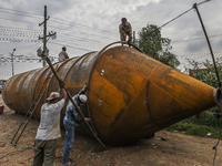 Labourer works on the construction of a cement silo in a factory at Savar, on the outskirts of Dhaka on June 16, 2021. (