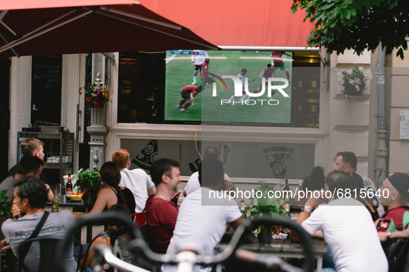 football fans are watching Euro 2020 match between Portugal and Germany in an outdoor restaurant in Bonn, Germany on June 19, 2021 