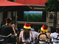 football fans are watching Euro 2020 match between Portugal and Germany in an outdoor restaurant in Bonn, Germany on June 19, 2021 (