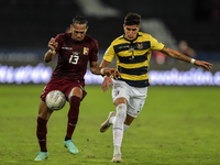 Matinez  player from Venezuela disputes a bid with Heyna player from Equador during a match at the Engenhão stadium for the Copa América 202...