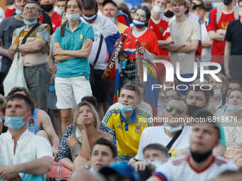 Ukraine supporter (C) watches a live stream alongside with Russian supporters during the UEFA Euro 2020 Championship match between Austra an...