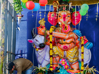 Man does final the decorating touches at a shrine with a large idol of Lord Ganesha (Lord Ganesh) along the roadside during the festival of...