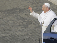 Pope Francis salutes faithful as he arrives for his weekly general audience with a limited number of faithful in the San Damaso Courtyard at...