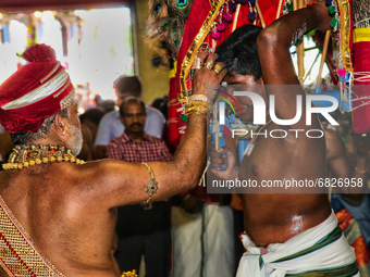 Tamil Hindu devotee receives blessings from a Hindu priest after performing the Kavadi Attam ritual (a ritual where he is pulled while danci...