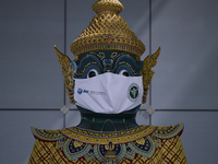 A large Ramayana Giant Guardian statue wears a face mask as part of a campaign to prevent the COVID-19 pandemic, at the nearly empty Suvarna...