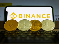 Binance logo displayed on a phone screen and representation of cryptocurrencies are seen in this illustration photo taken in Krakow, Poland...
