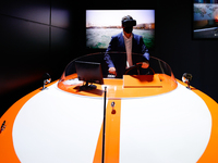 A congress attendant experiencing the 5g connectivity driving a boat remotely at the Orange Telecom pavilion, during the second day of Mobil...