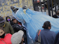 A person carries a figure of Santa Muerte in Tepito, Mexico City, Mexico, on July 1, 2021, outside her church before a rosary led by Enrique...