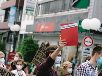 an activist holds a red card during the Fridays for Future demo in Bonn, Germany on July 2, 2021 for better climate protection (