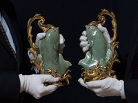 LONDON, UNITED KINGDOM - JULY 05, 2021: Staff members hold a pair of Louis XV ormolu-mounted Chinese celadon porcelain carp vases, estimate...