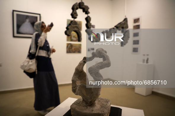 Palestinians attend an exhibition of photos and sculptures 