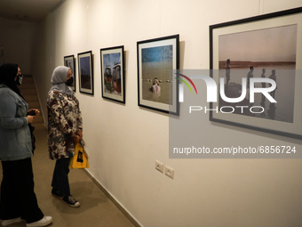 Palestinians attend an exhibition of photos and sculptures 
