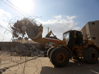 Egyptian workers and machines clear the remaining rubble of Al-Jalaa tower, a building that was levelled in an Israeli attack during the 11-...