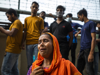 Relatives of the victims mourn at the site where a fire broke out at Hashem Foods Ltd in Rupganj, on the outskirts of Dhaka, Bangladesh, Jul...