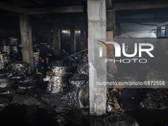 Firefighter's and rescue workers works inside the burned factory building after they managed to douse the fire at the Hashem Foods Ltd  in R...