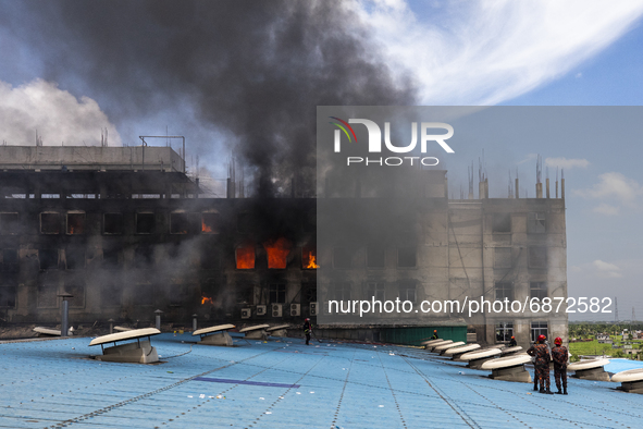 Firefighter's and rescue workers try to extinguish a massive fire that broke out at the Hashem Foods Ltd at Rupganj, on the outskirts of Dha...