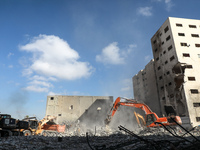 Palestinian workers collect the rubble of Al-Jalaa tower, levelled by an Israeli air strike during the May 2021 conflict between Israel and...
