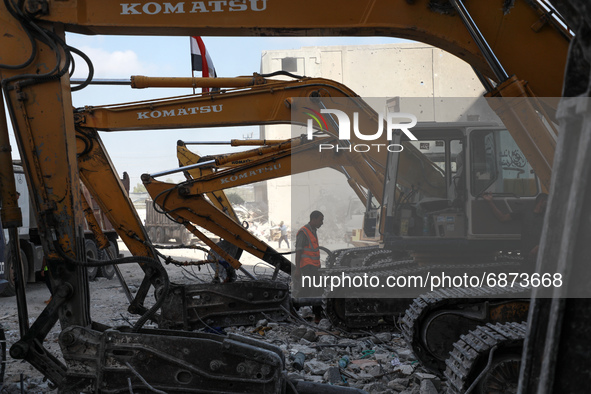 Palestinian workers collect the rubble of Al-Jalaa tower, levelled by an Israeli air strike during the May 2021 conflict between Israel and...