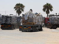 Trucks loaded with goods enter the Gaza Strip from Israel through the Kerem Shalom crossing in Rafah in the southern Gaza Strip on July 14,...