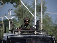 An Indian paramilitary soldier looks on from top of an armoured vehicle during an encounter at Alamdar Colony Danmar, Syedpora area of Srina...