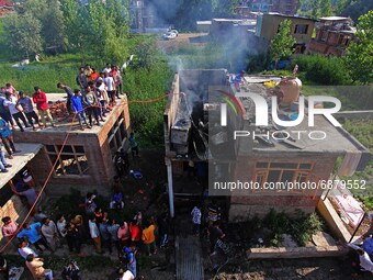 People gather near the house which was damaged by Indian forces during an encounter at Alamdar Colony Danmar, Syedpora area of Srinagar,Kash...