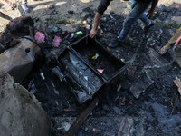 A Kashmiri man recovers the remains from a damaged residential house where two Militants were killed in a military operation in Srinagar, In...