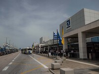 Exterior of the departure area, cafe, public bus and entrance of Athens Airport. Passengers with face masks as seen at Athens International...