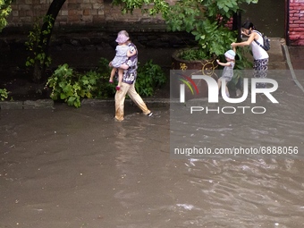 People walk on a flooded street during a heavy downpour  during a heavy downpour in Kyiv, Ukraine. July 19, 2021  (