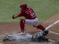 Shane Robinson #23 of the Monclova Acereros  dives into home plate ahead of the tag  during the match between Diablos Rojos and Monclova Ace...