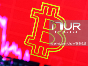 Bitcoin cryptocurrency sign and a graph are pictured in Kyiv on 19 July, 2021. (