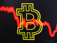 Bitcoin cryptocurrency sign and a graph are pictured in Kyiv on 19 July, 2021. (